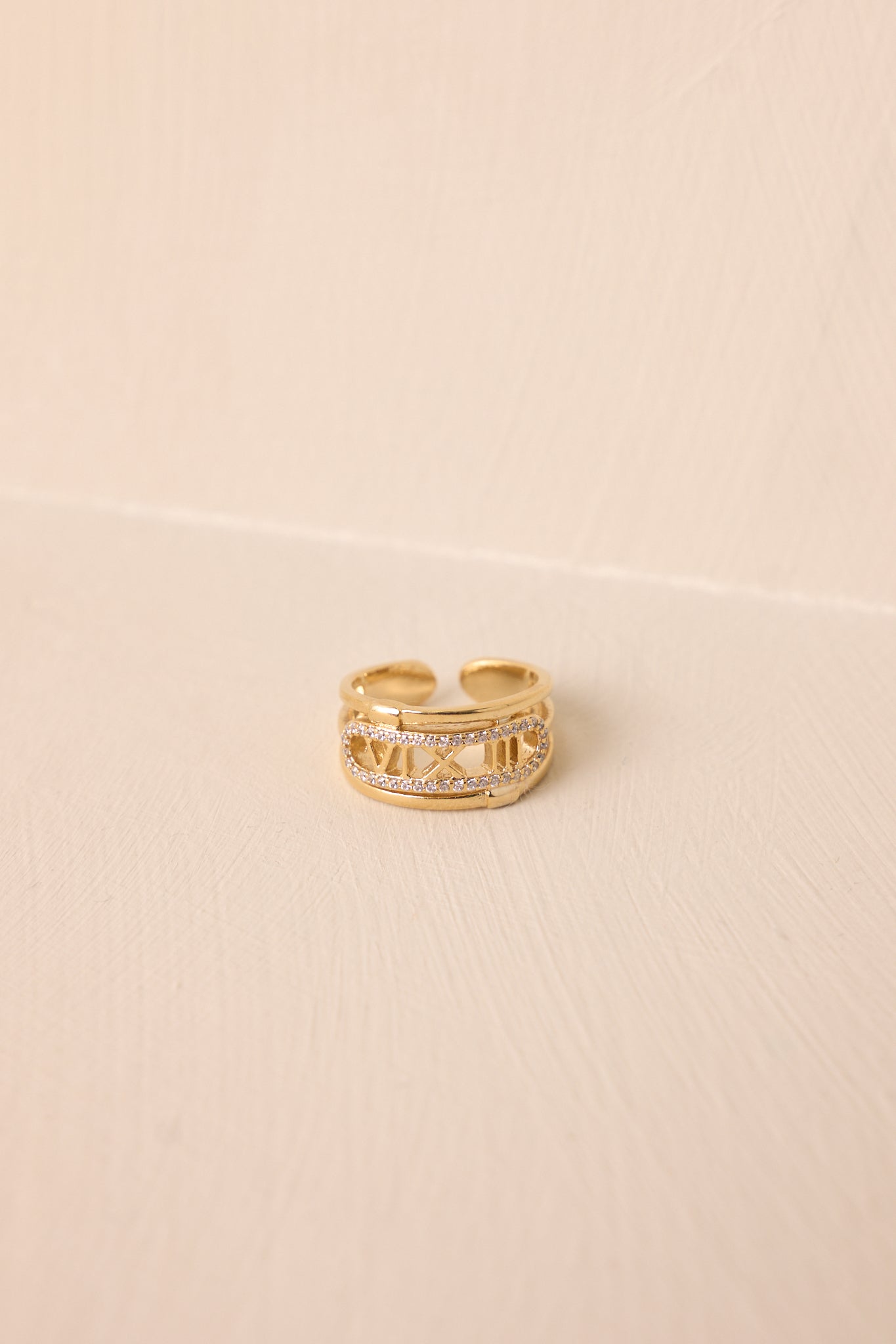 A close-up of the gold ring showcasing the sectioned-off middle section with Roman numerals "six, ten & three."