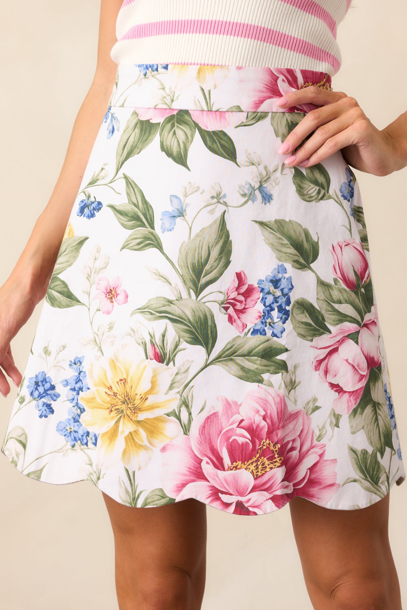 A closer view of the ivory skirt's scalloped hem and multicolor floral print, emphasizing the delicate details and vibrant design.