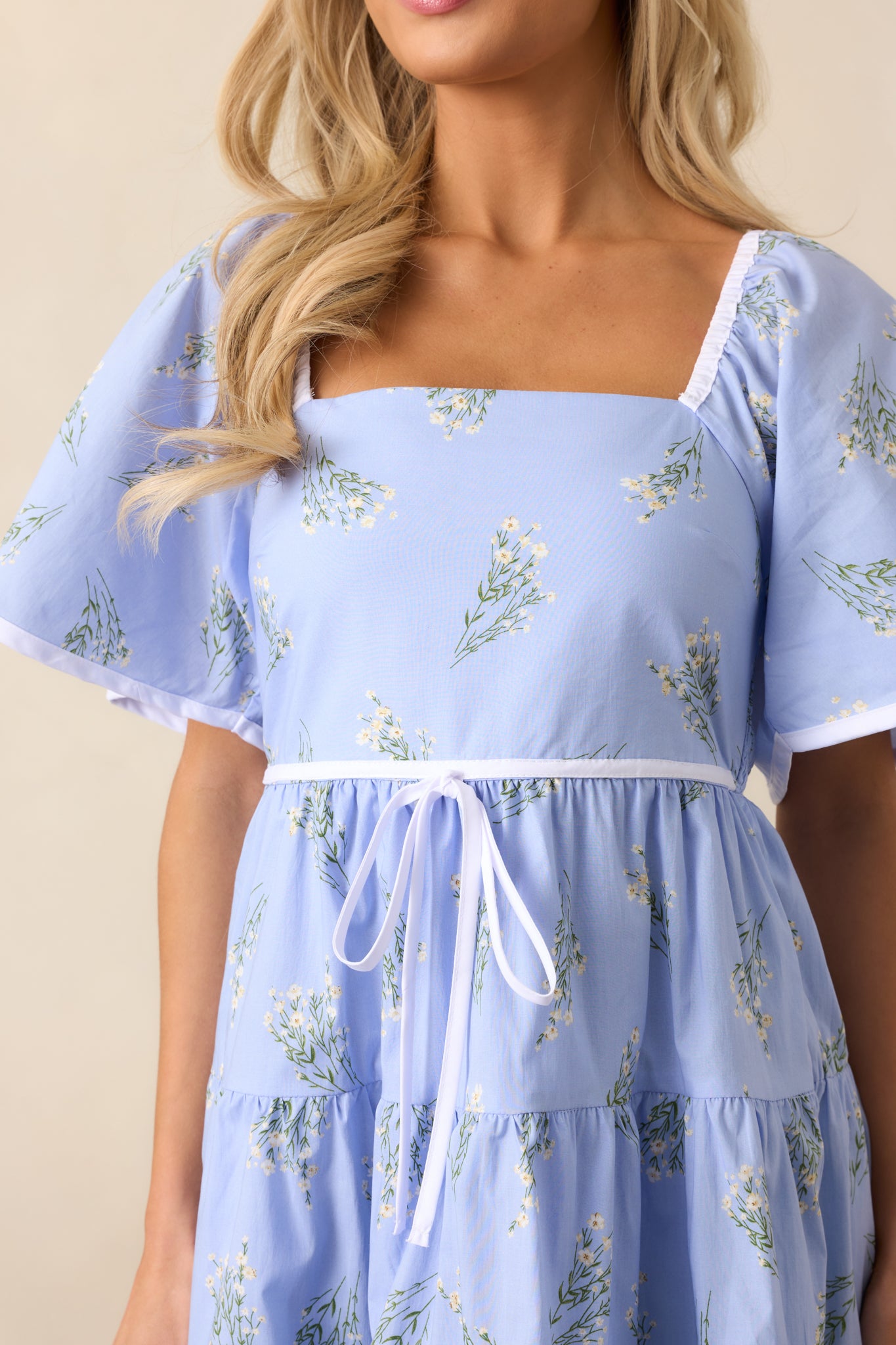 A close-up of the smocked back panel and delicate floral print of the dress, showcasing the intricate texture and stretch.