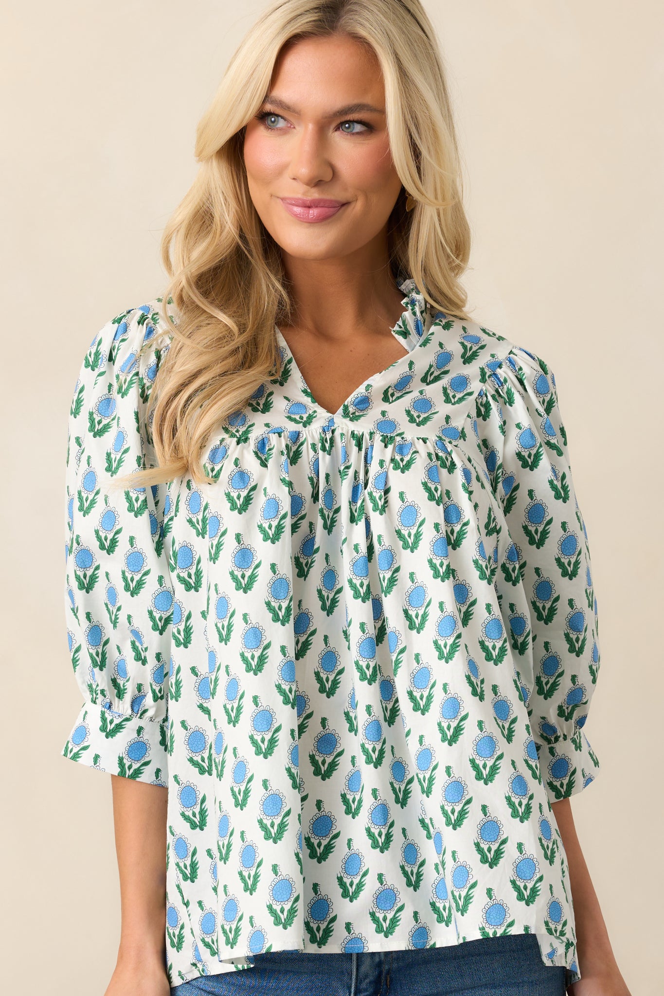 A closer look at the upper portion of the top, highlighting the ruffle-trimmed notch V-neckline and floral pattern.