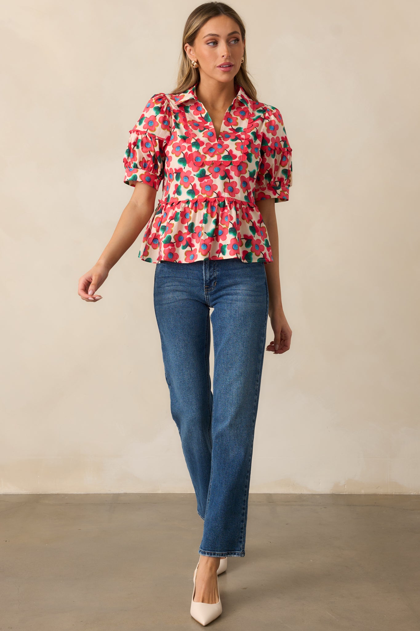 A floral-print red top featuring ric rac detailing throughout, a structured collar, and a flowy peplum hem.