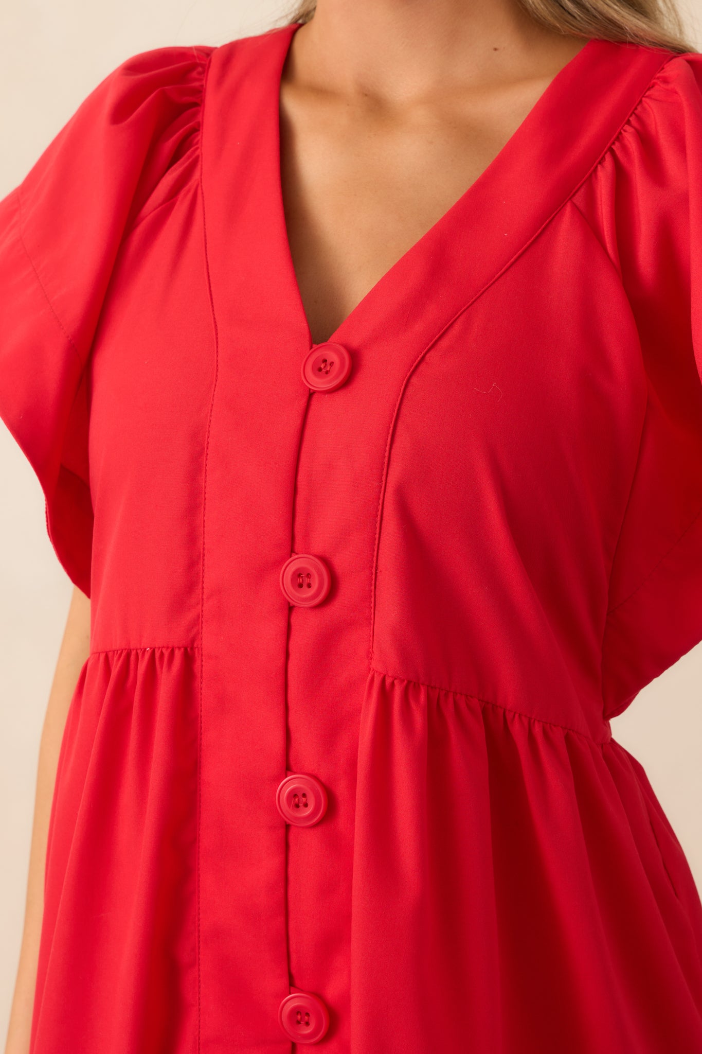 A zoomed-in shot of the button front design, highlighting the red buttons and the fabric texture.