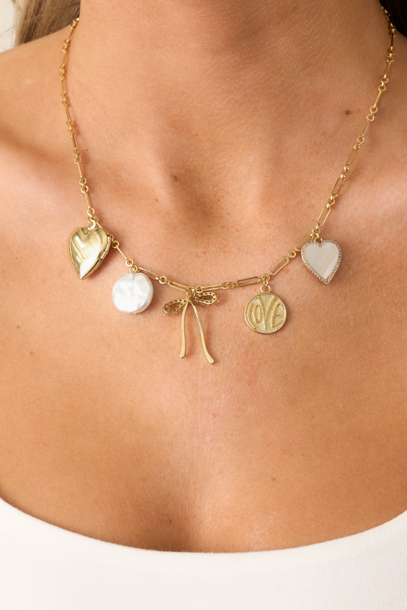A zoomed-in look at the intricate charm details, showcasing the delicate mix of textures and finishes, including the pearlescent, rhinestone, and engraved elements.