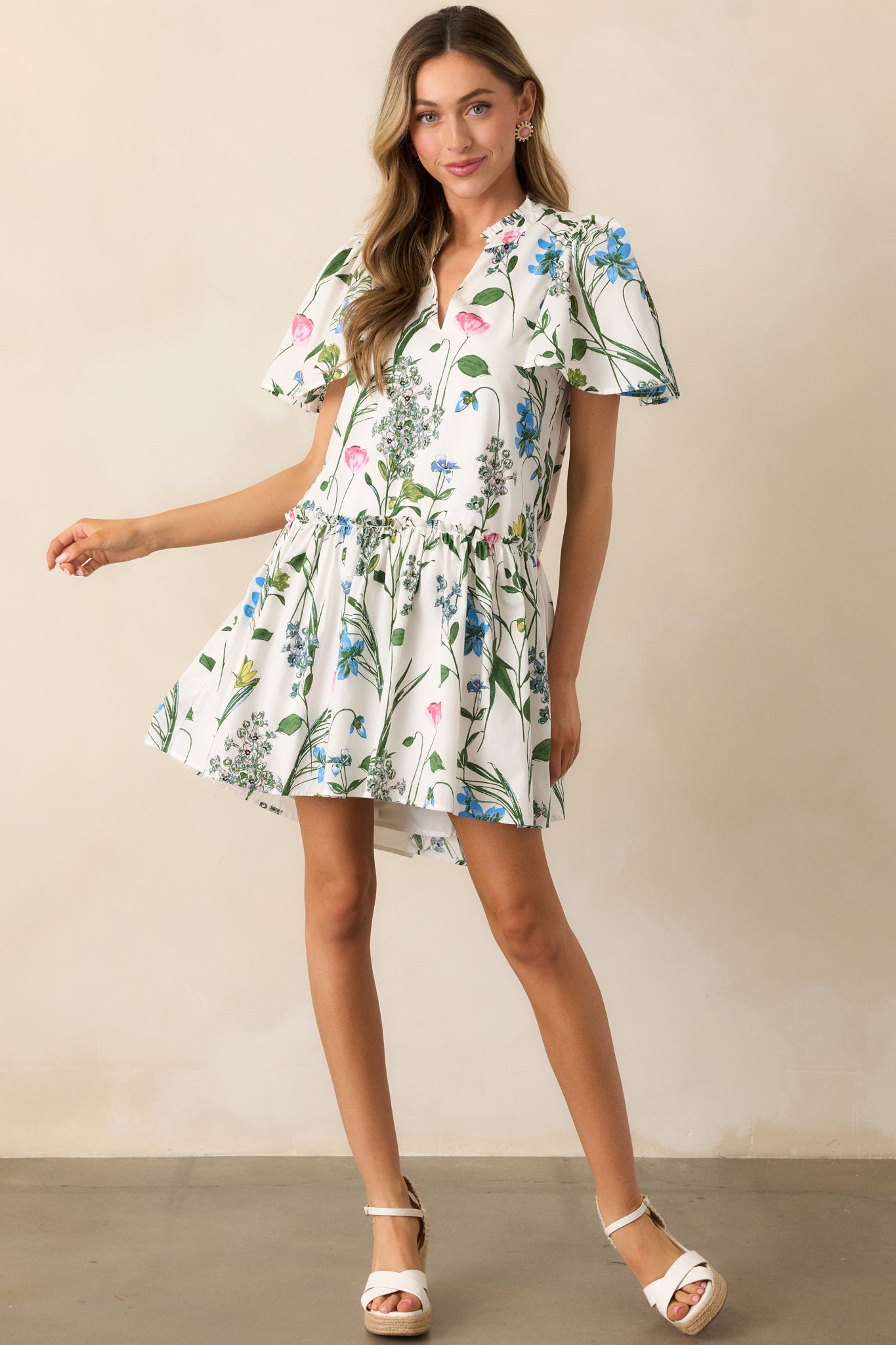 A mini dress with a lively multicolor floral print, a notch v-neckline, and soft butterfly sleeves.
