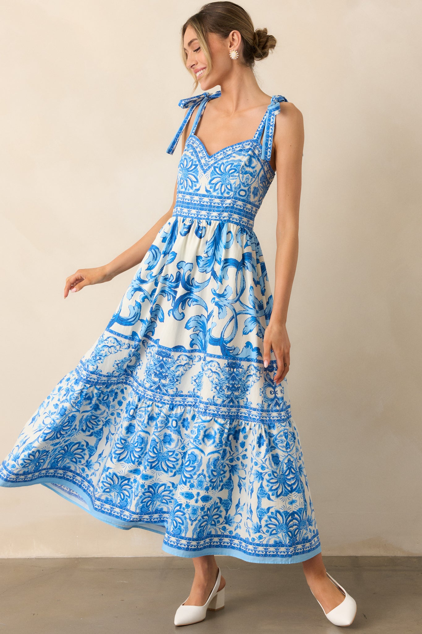 A vibrant blue midi dress with intricate tile-inspired patterns, a sweetheart neckline, and a smocked back panel for added comfort.
