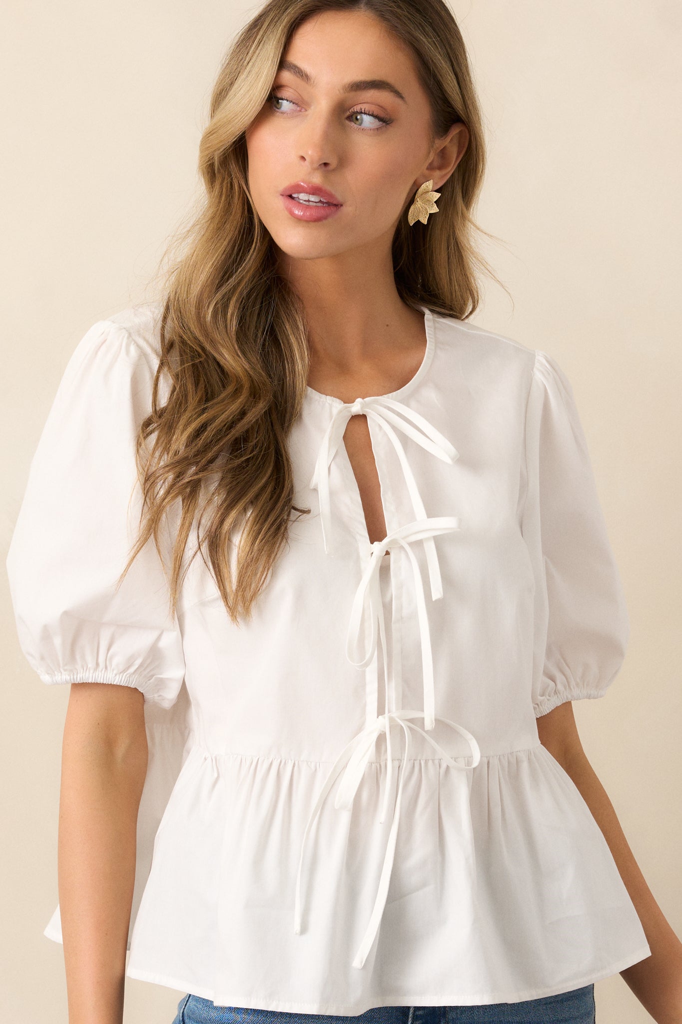 The short puff sleeves with elastic cuffs, offering a soft, billowy effect that complements the peplum style of the top.