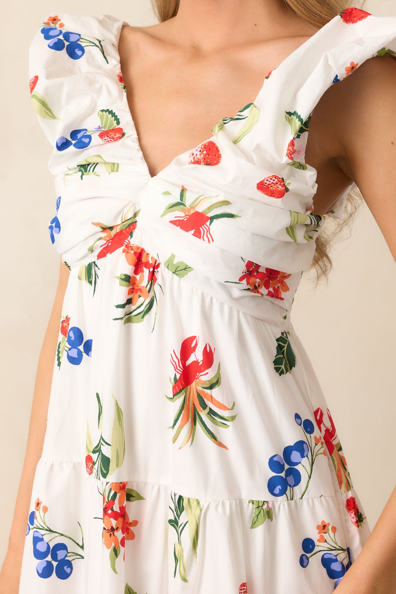 A close-up of the white dress’s ruched bust and flutter puff sleeves, highlighting soft gathers and delicate shaping.
