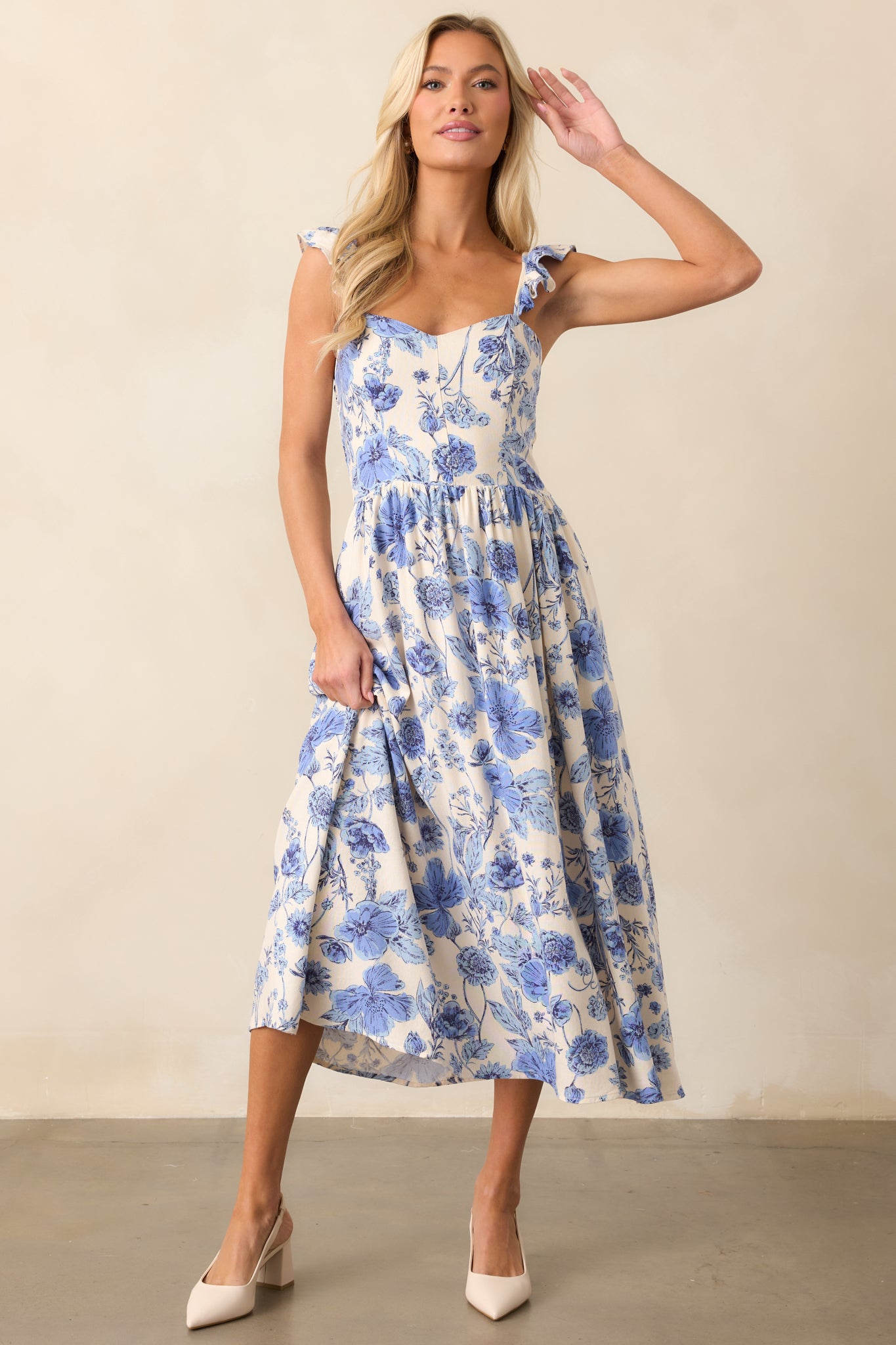 A blue floral dress with a sweetheart neckline, adjustable ruffled straps, and functional hip pockets, shown from the front. The lightweight fabric drapes naturally.