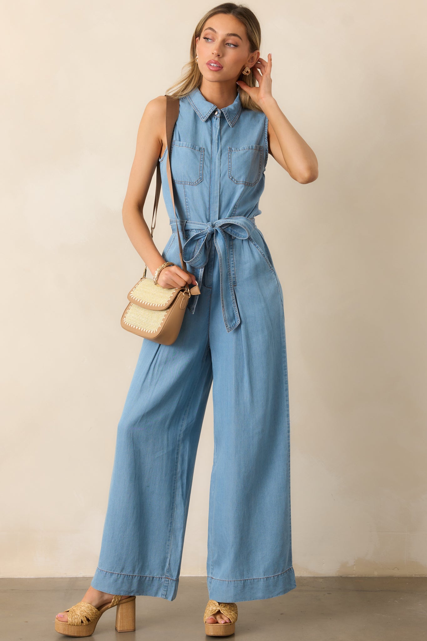 The lightweight chambray fabric and tailored details create a sleek and versatile sleeveless jumpsuit.