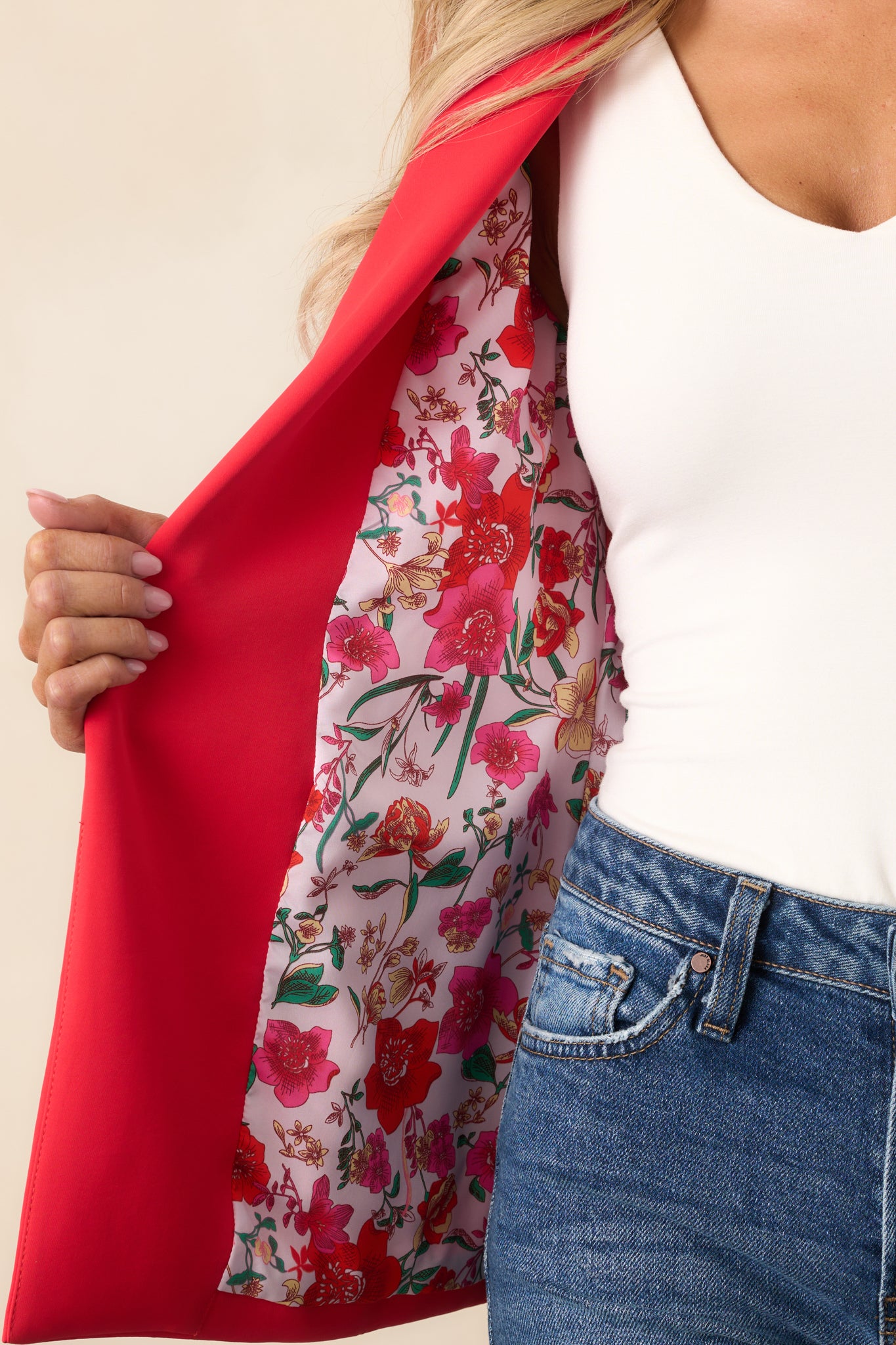  A detailed view of the red blazer’s fabric, highlighting the texture and showing off the hidden floral lining.