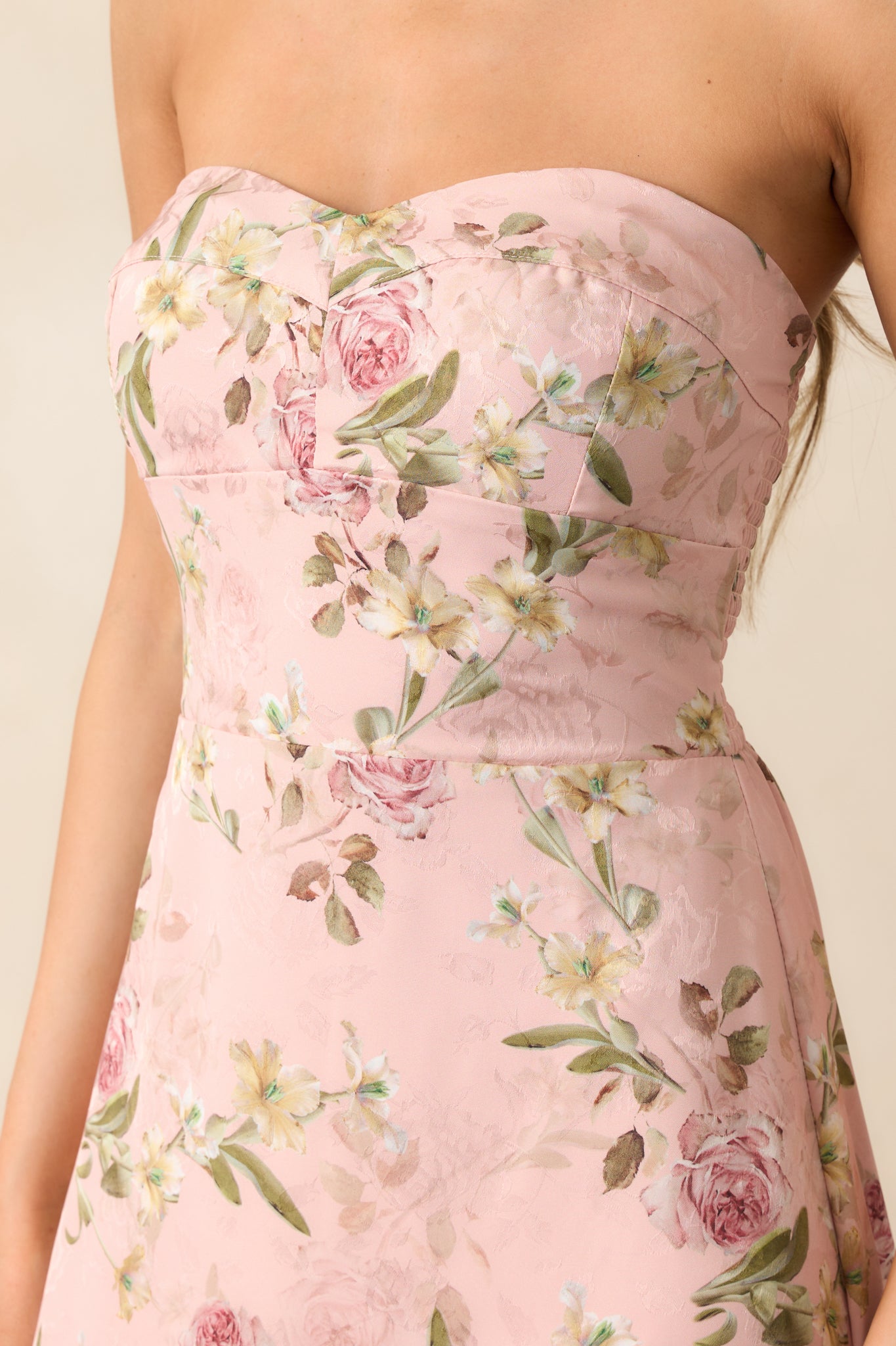 A close-up of the strapless neckline of the light pink dress, highlighting the non-slip strips along the top hem for a secure fit, and the soft fabric texture.