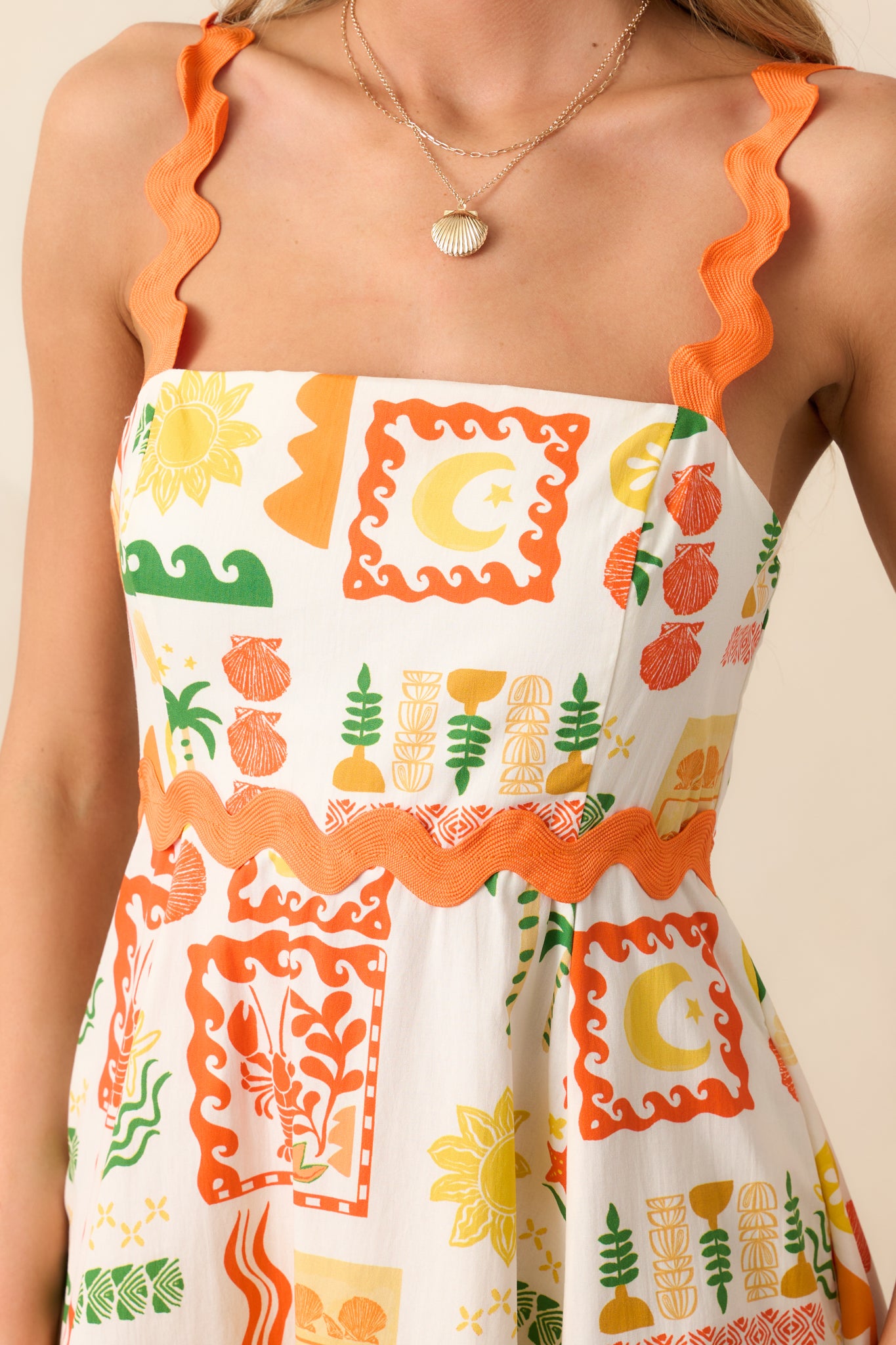 A close-up of the ric rac straps and square neckline, showcasing the intricate trim and vibrant tropical print.