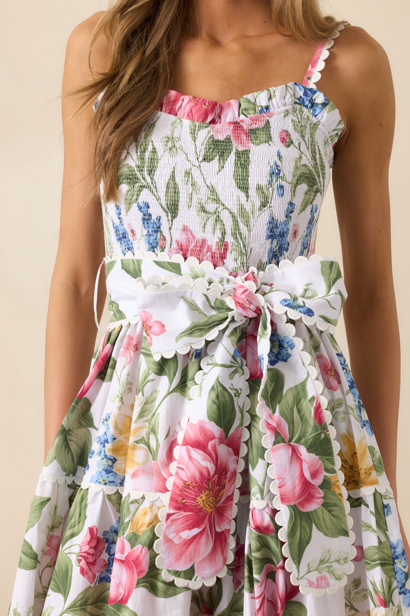 A close-up of the floral dress showcasing its multicolor floral print, smocked bust, and ric rac detailing throughout for added texture.