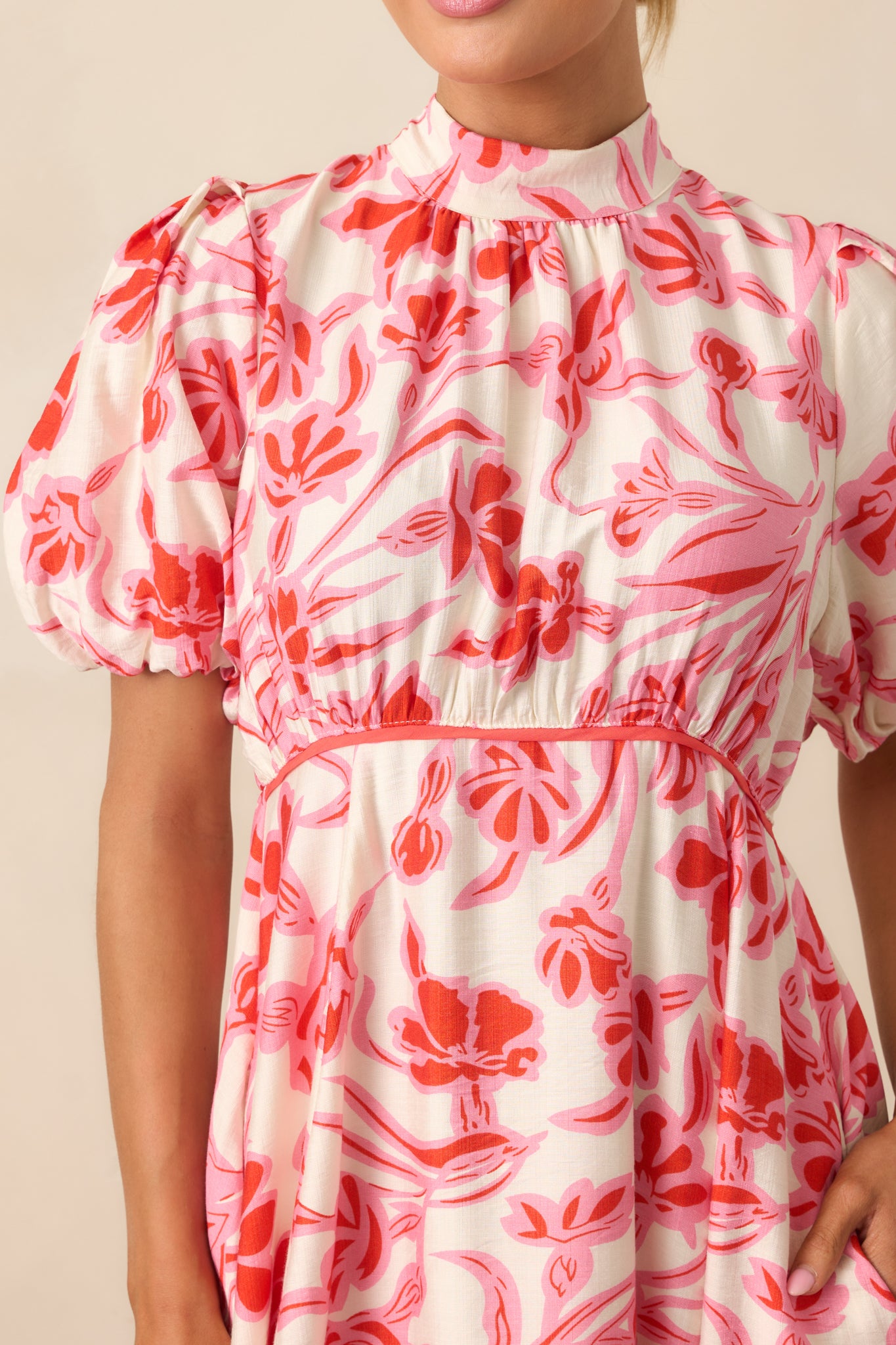  A detailed look at the floral print and self-tie mock neckline, adding a touch of elegance to the midi dress.