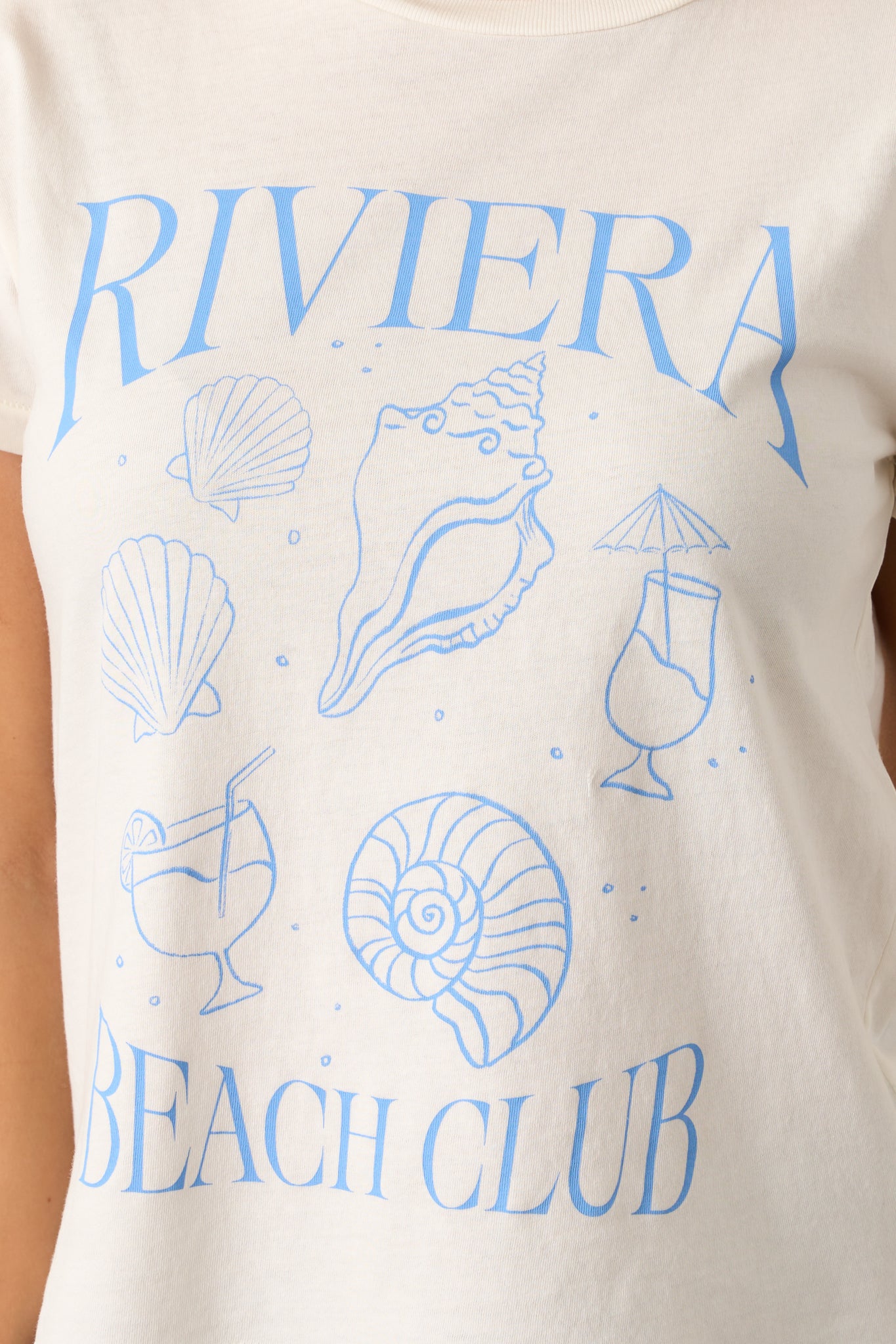 A close-up of the Riviera Beach Club graphic on the top, showing the vibrant design printed on the 100% cotton jersey fabric with a focus on the clean, smooth texture
