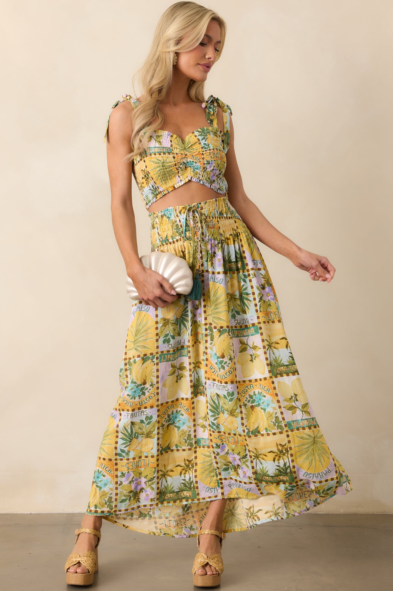 Flowy and vibrant, this tropical print maxi skirt features a wide smocked waistband and a self-tie waist with green tassels, creating a relaxed yet stylish look for any occasion.