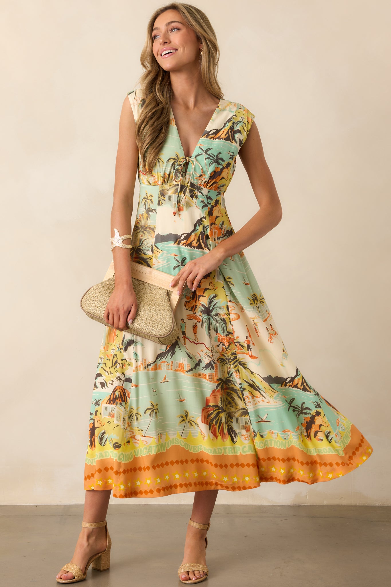 A vibrant tropical-print midi dress with cap sleeves, an adjustable tie-front detail, and a flowing silhouette.