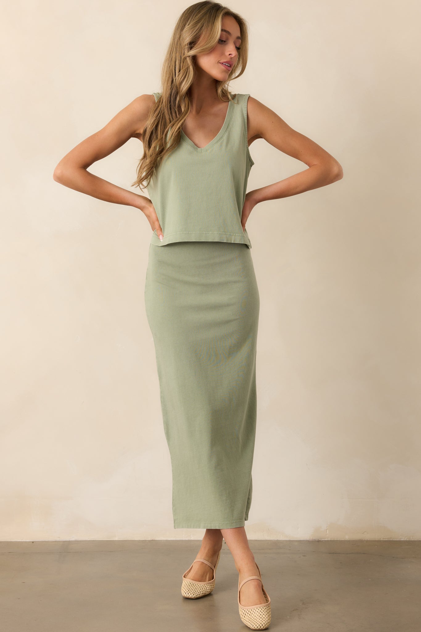 A green midi skirt with a slightly fitted silhouette, an elastic waistband, and a comfortable mid-rise waist.