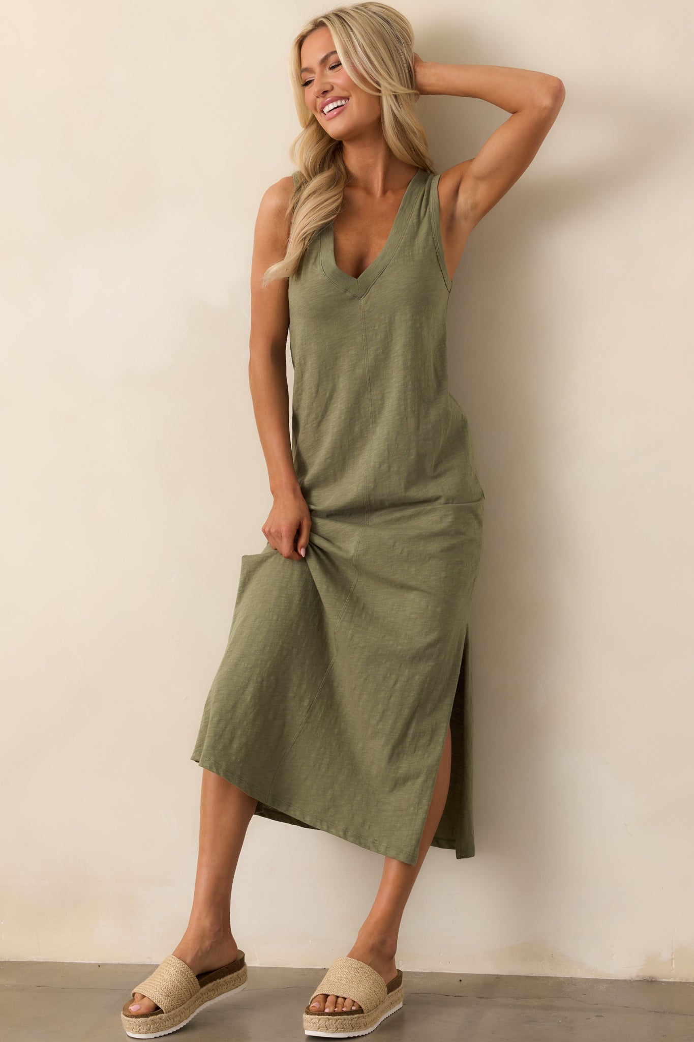 This avocado green dress features a v-neckline and a sleeveless design, made from lightweight cotton fabric for a breezy feel. Leg slits on both sides add a touch of movement and style, perfect for warm weather.