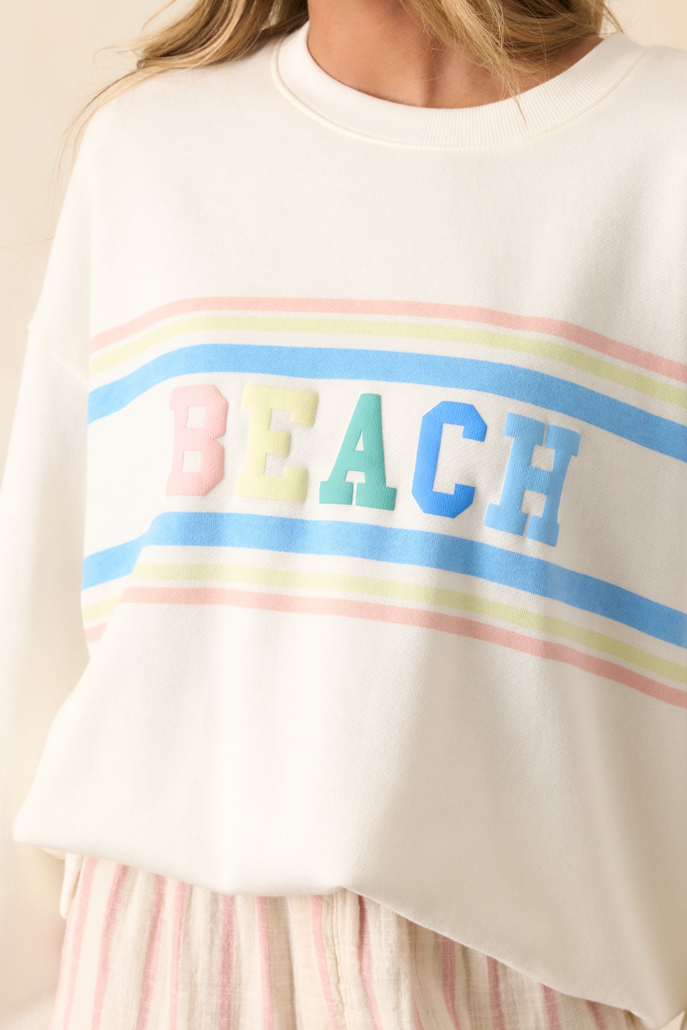 A close-up of the "Beach" multicolor script and striped details, showcasing the bold lettering and contrasting colors that make this sweatshirt stand out.