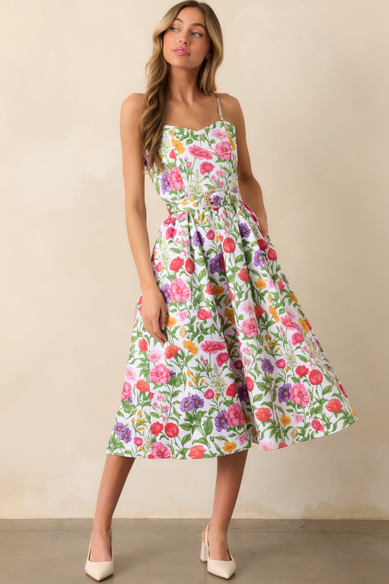 The floral dress displayed in a full-length shot, highlighting the adjustable spaghetti straps and structured bodice.