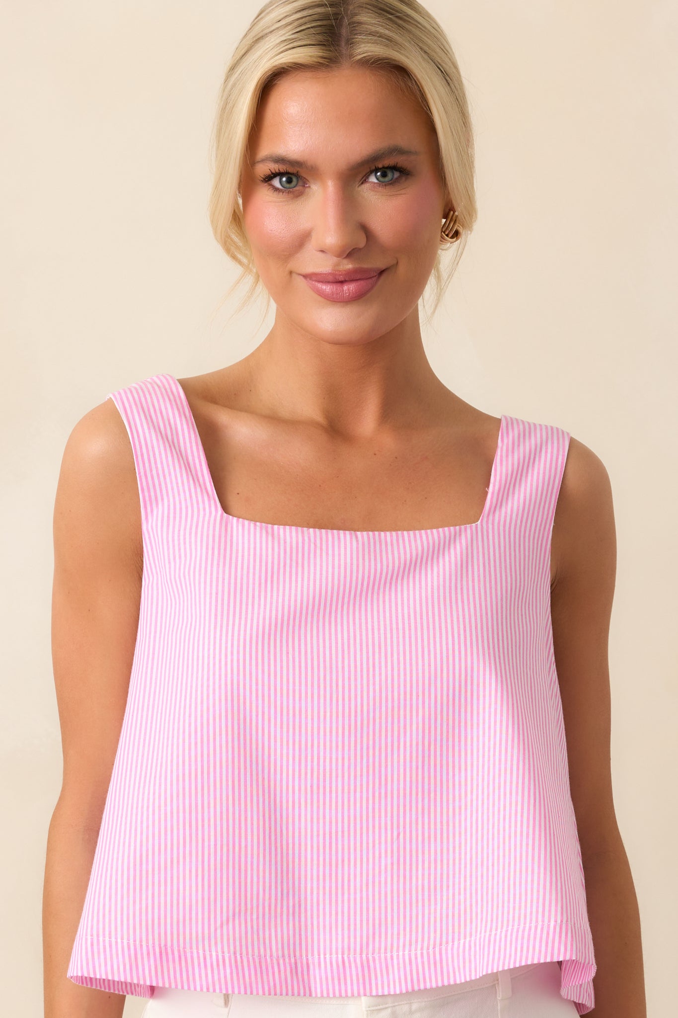 A peony pink striped top with a square neckline, sleeveless tank design, and cropped length for a fresh and stylish look.