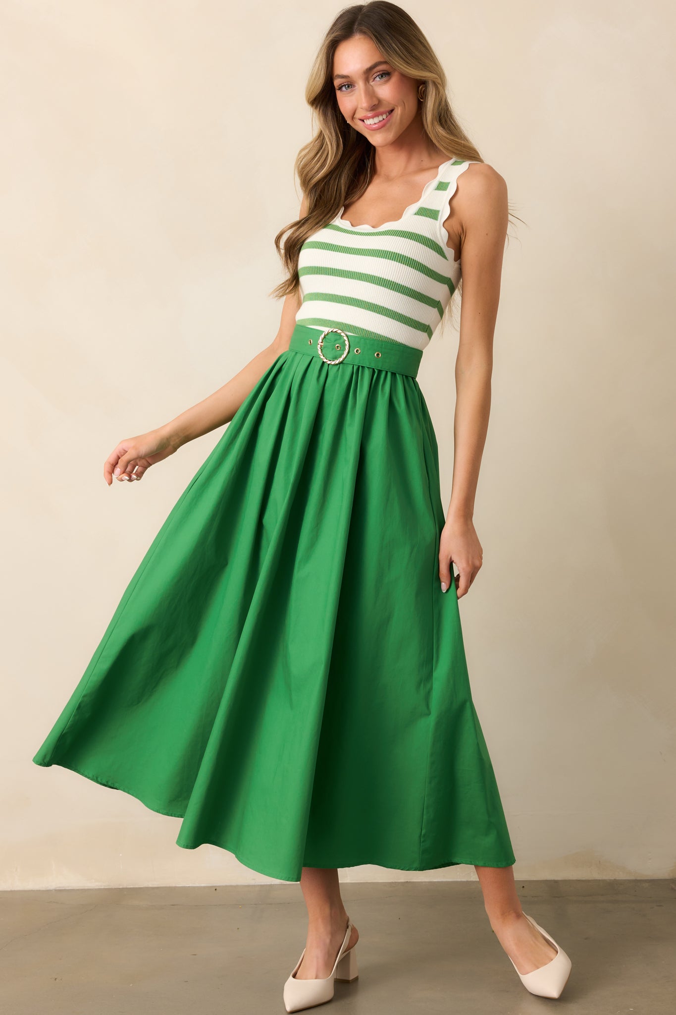 The scalloped hems on the striped knit top add a delicate detail, complementing the flowy solid skirt.